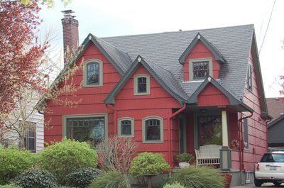 casa-rosie-acoperis-negru Casa cu fatada rosie si gradina verde in fata